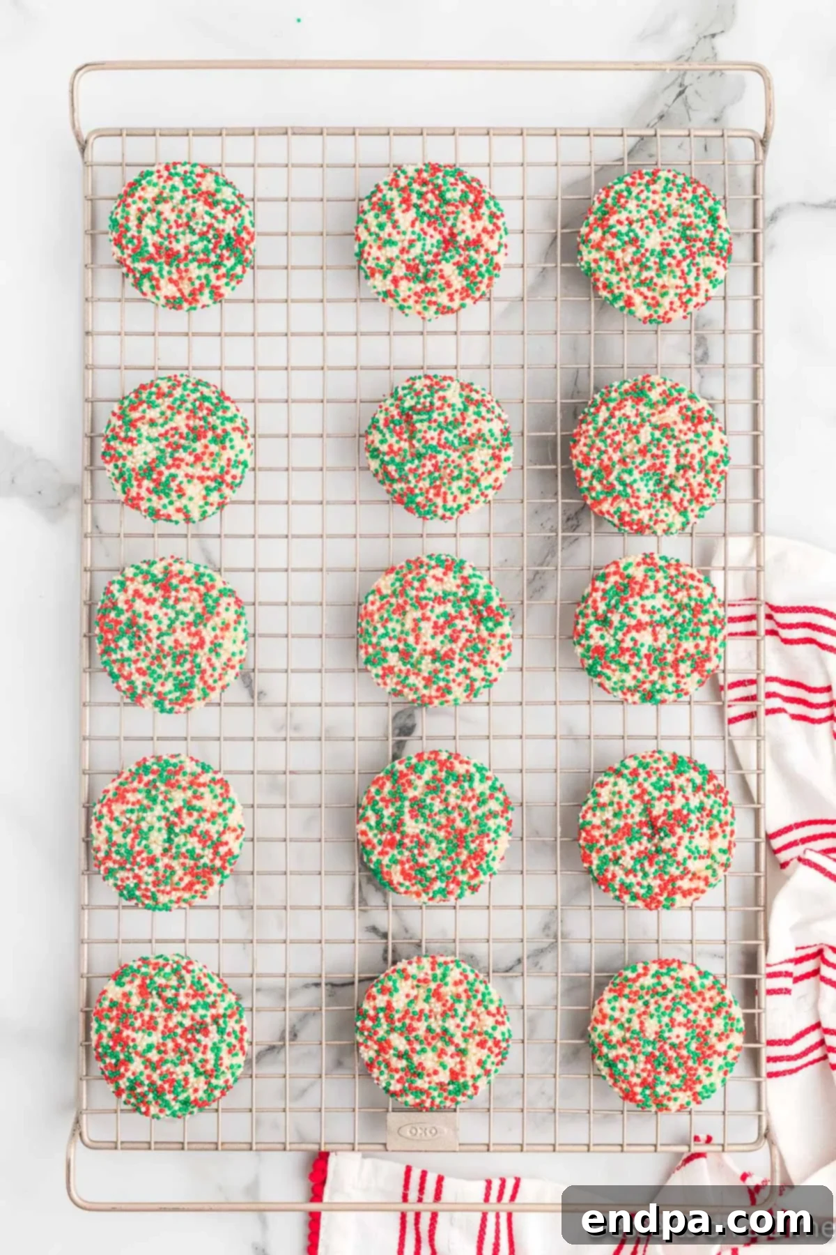 Fully cooled Christmas sprinkle cookies arranged on a wire rack, showcasing their vibrant colors and perfect round shape, ready to be enjoyed.