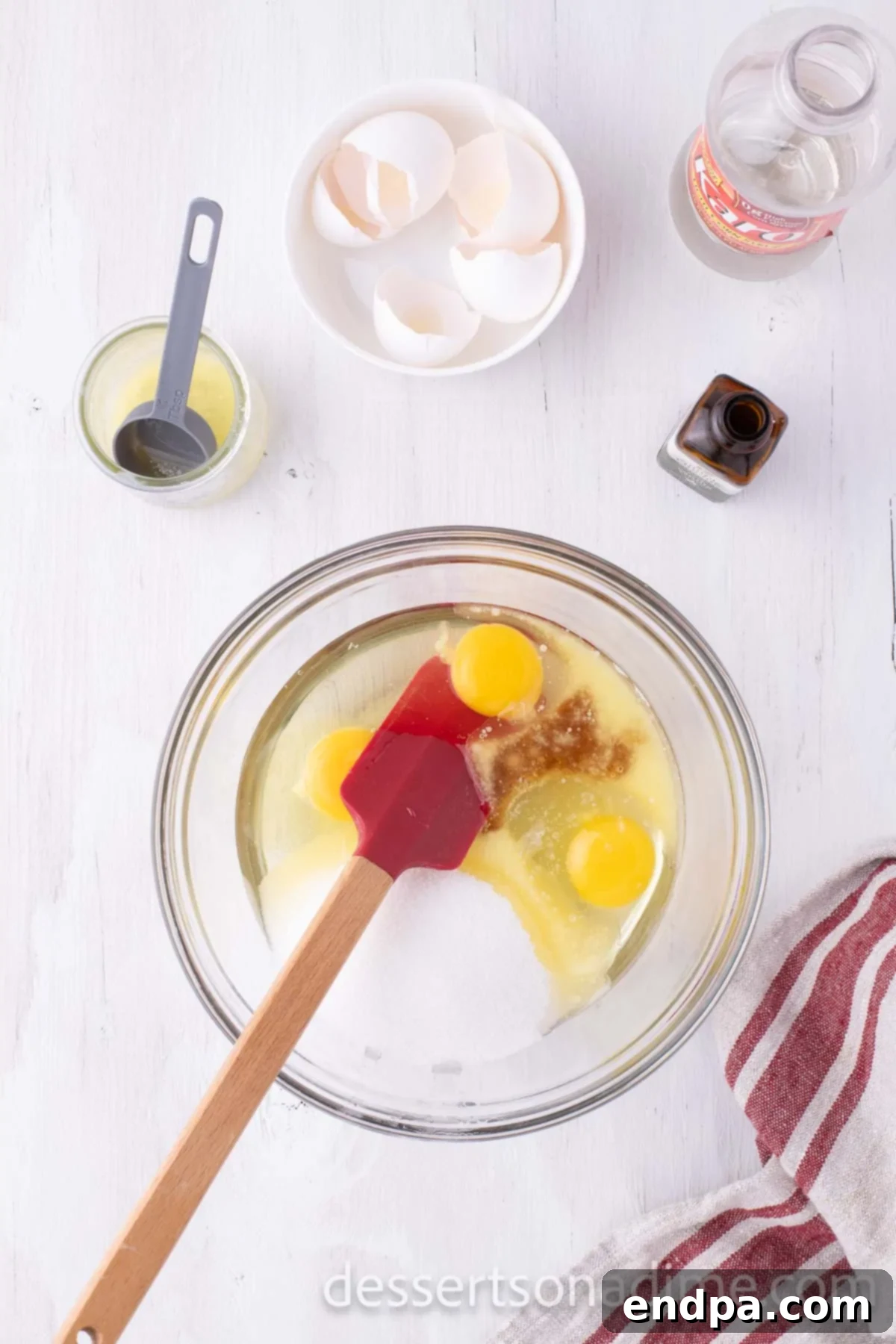 Perfect Karo Syrup Pecan Pie 4 A large mixing bowl containing corn syrup, eggs, melted butter, and vanilla extract, ready to be stirred together for the pecan pie filling.