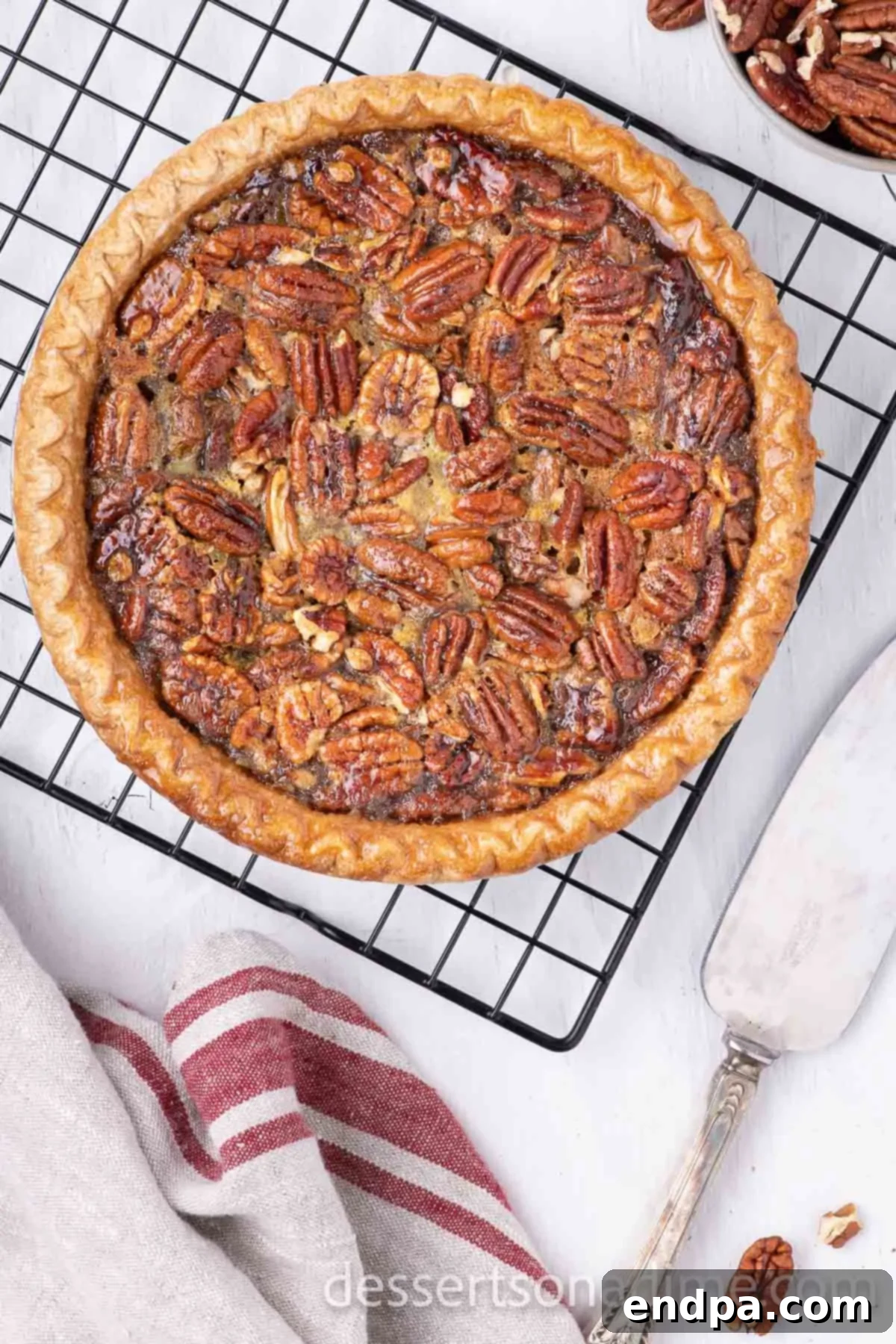 Perfect Karo Syrup Pecan Pie 6 A freshly baked pecan pie cooling on a wire rack, with its golden-brown crust and glistening, set filling.