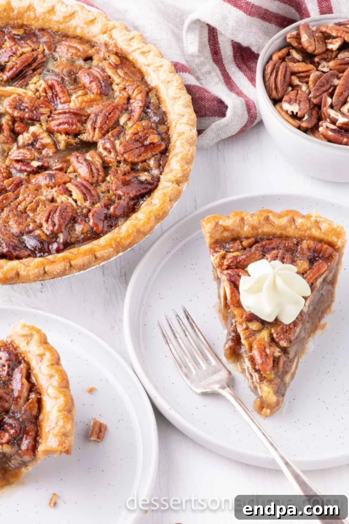 Perfect Karo Syrup Pecan Pie 8 A close-up shot of a single slice of pecan pie topped with a swirl of whipped cream, highlighting the gooey filling and crunchy pecans.