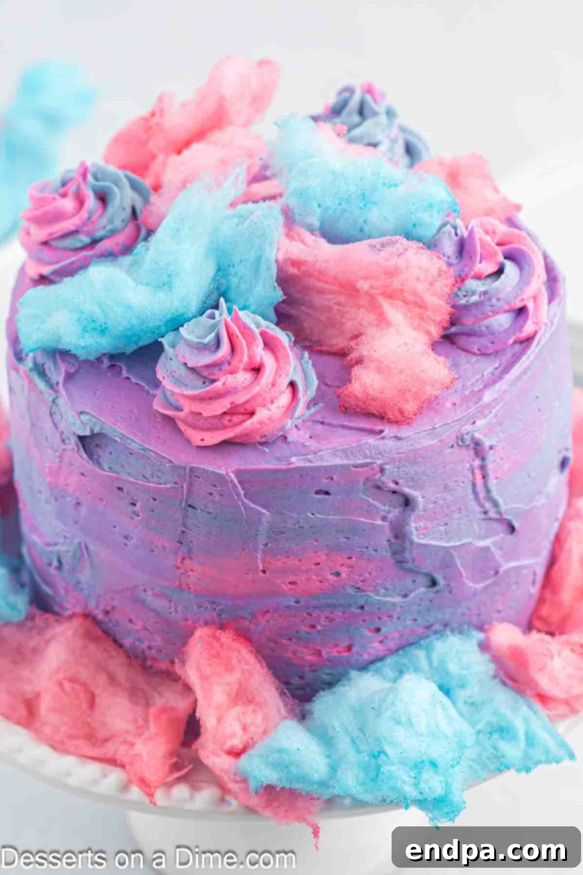 Cake fully frosted with multi-colored buttercream layers and swirls on top.