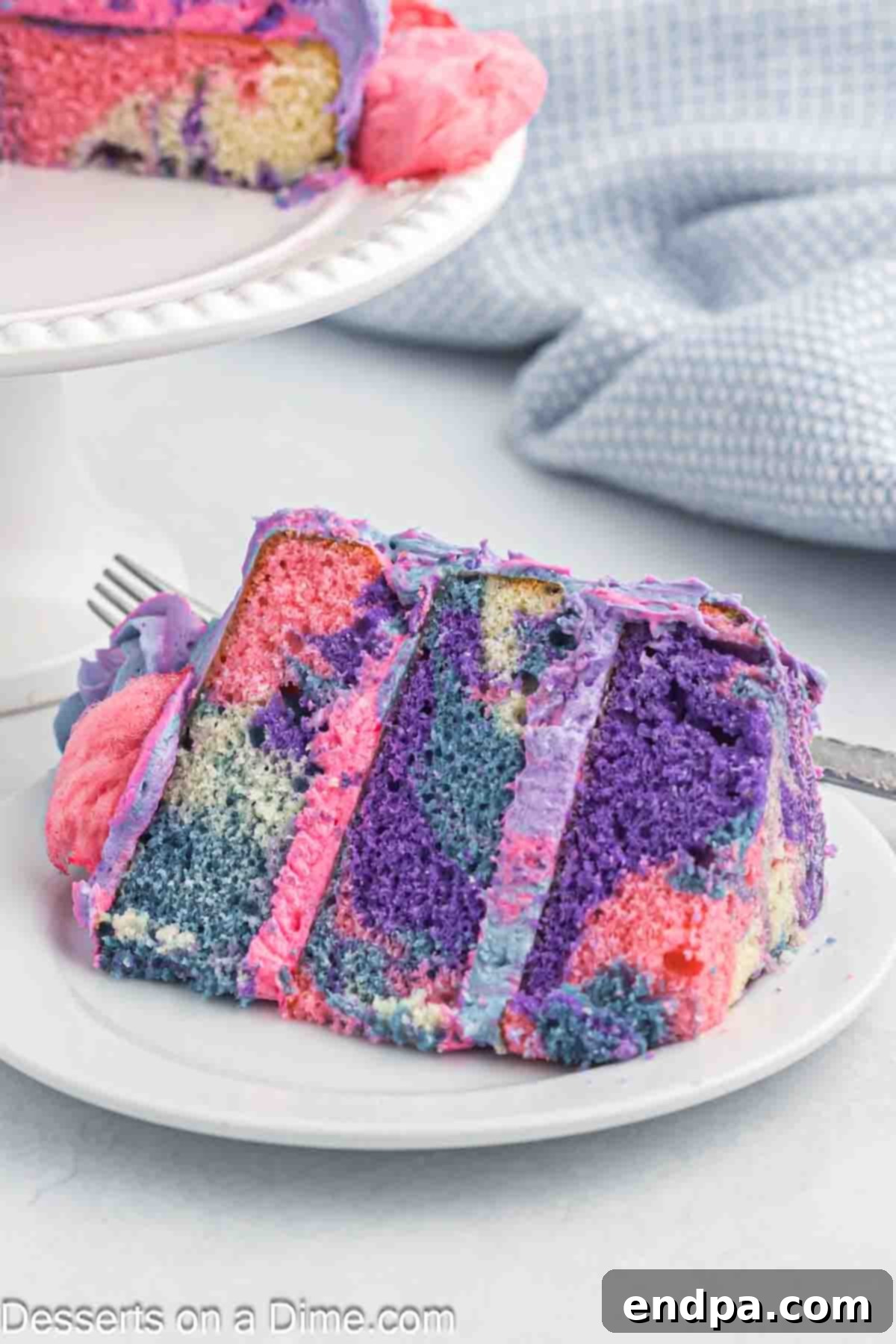 Cotton Candy Cake sliced on a plate, revealing vibrant layers.