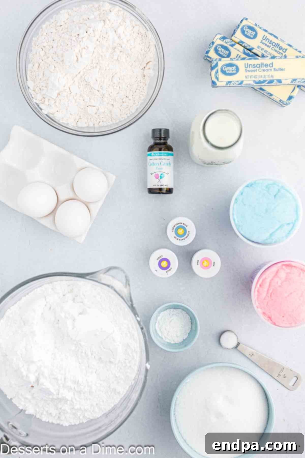 Cotton Candy Cake ingredients laid out - flour, butter, sugar, large eggs, cotton candy flavoring, milk, gel food coloring, powdered sugar, milk.