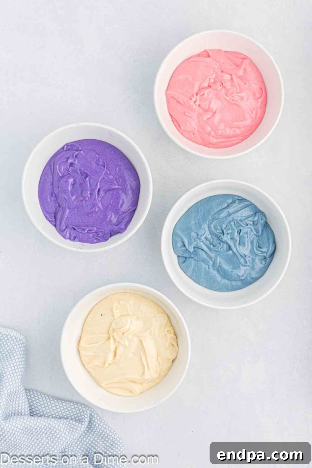 Batter divided into bowls and different gel food coloring added to each.