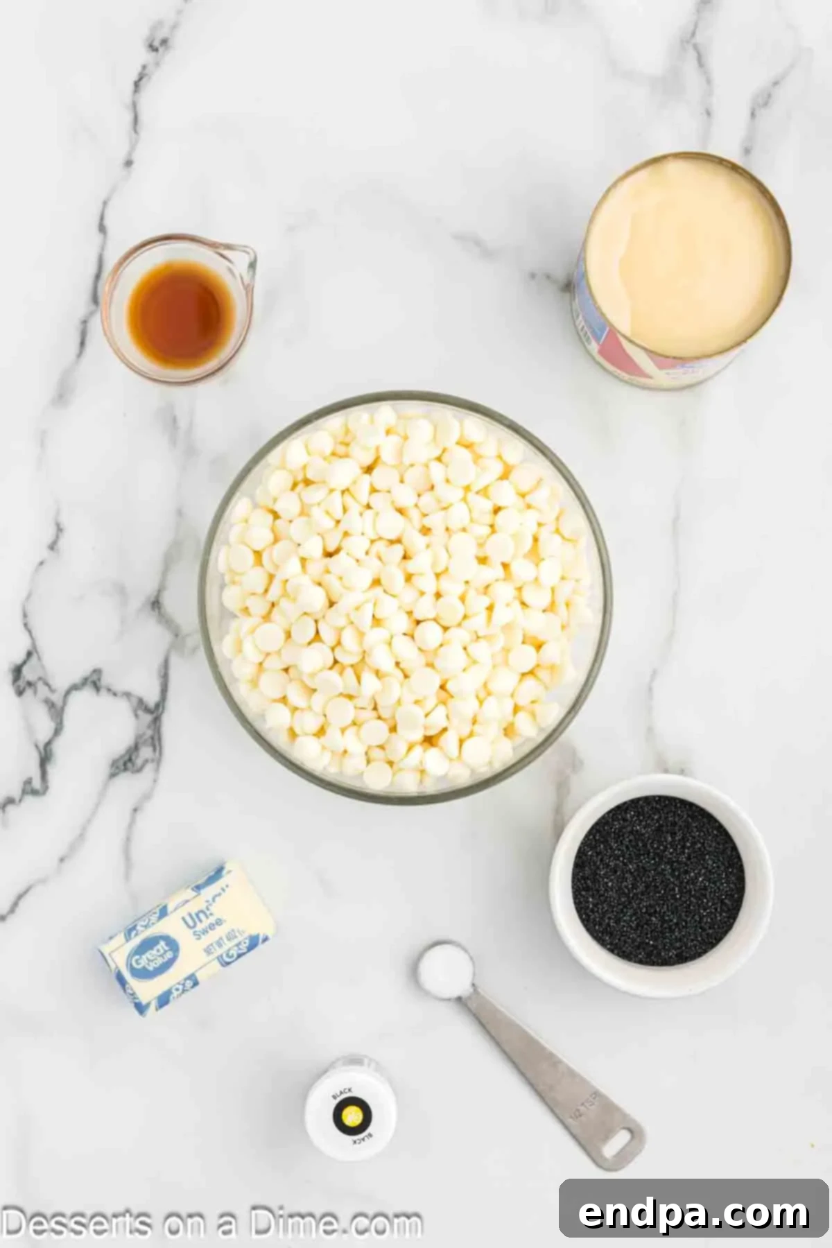 Naughty List Fudge 3 A flat lay of all the ingredients needed to make Christmas Coal Fudge, including white chocolate chips, condensed milk, butter, vanilla extract, and black food coloring.