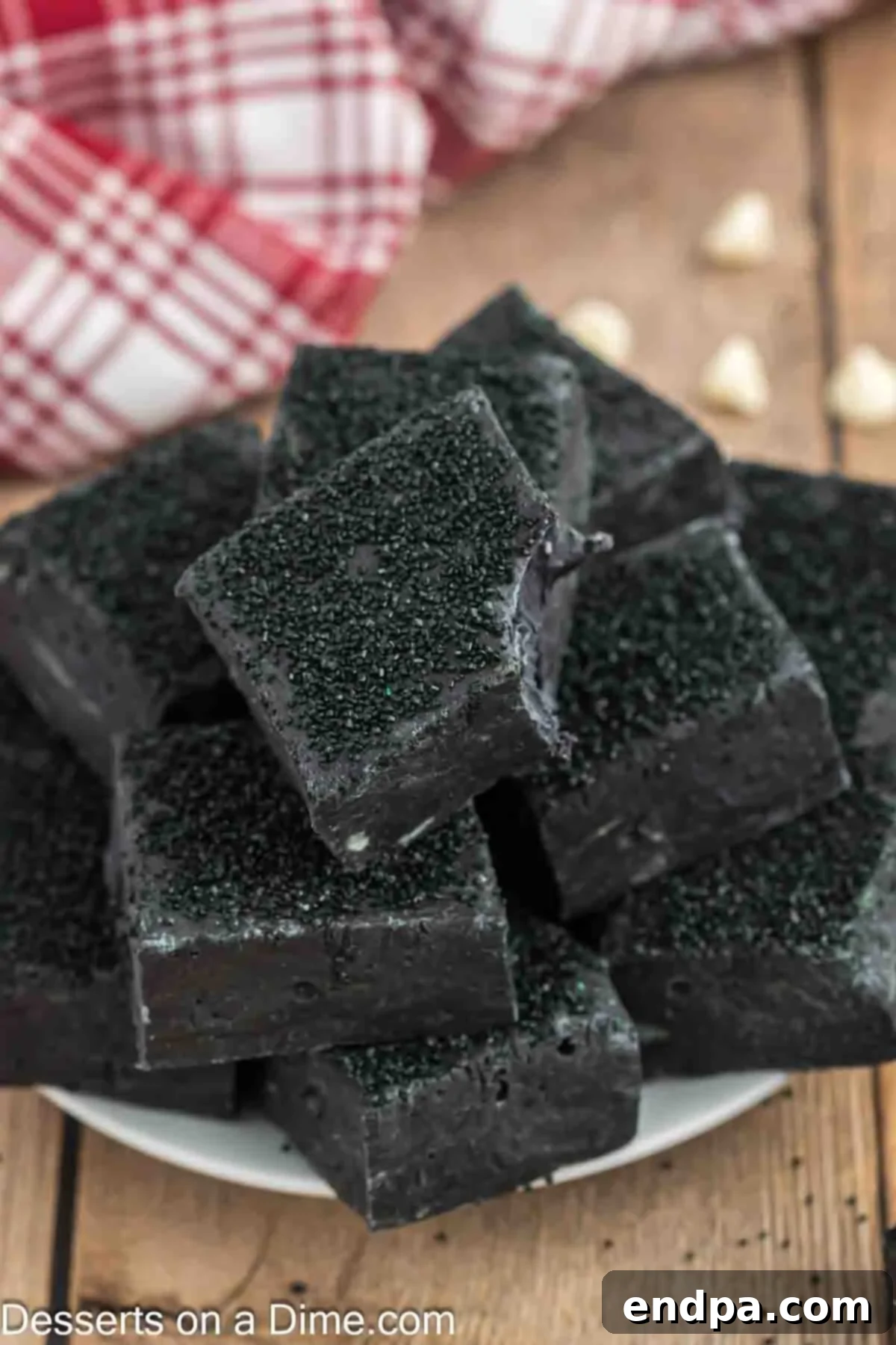 Naughty List Fudge 8 Close-up of perfectly cut squares of Christmas Coal Fudge, sprinkled with black sanding sugar.