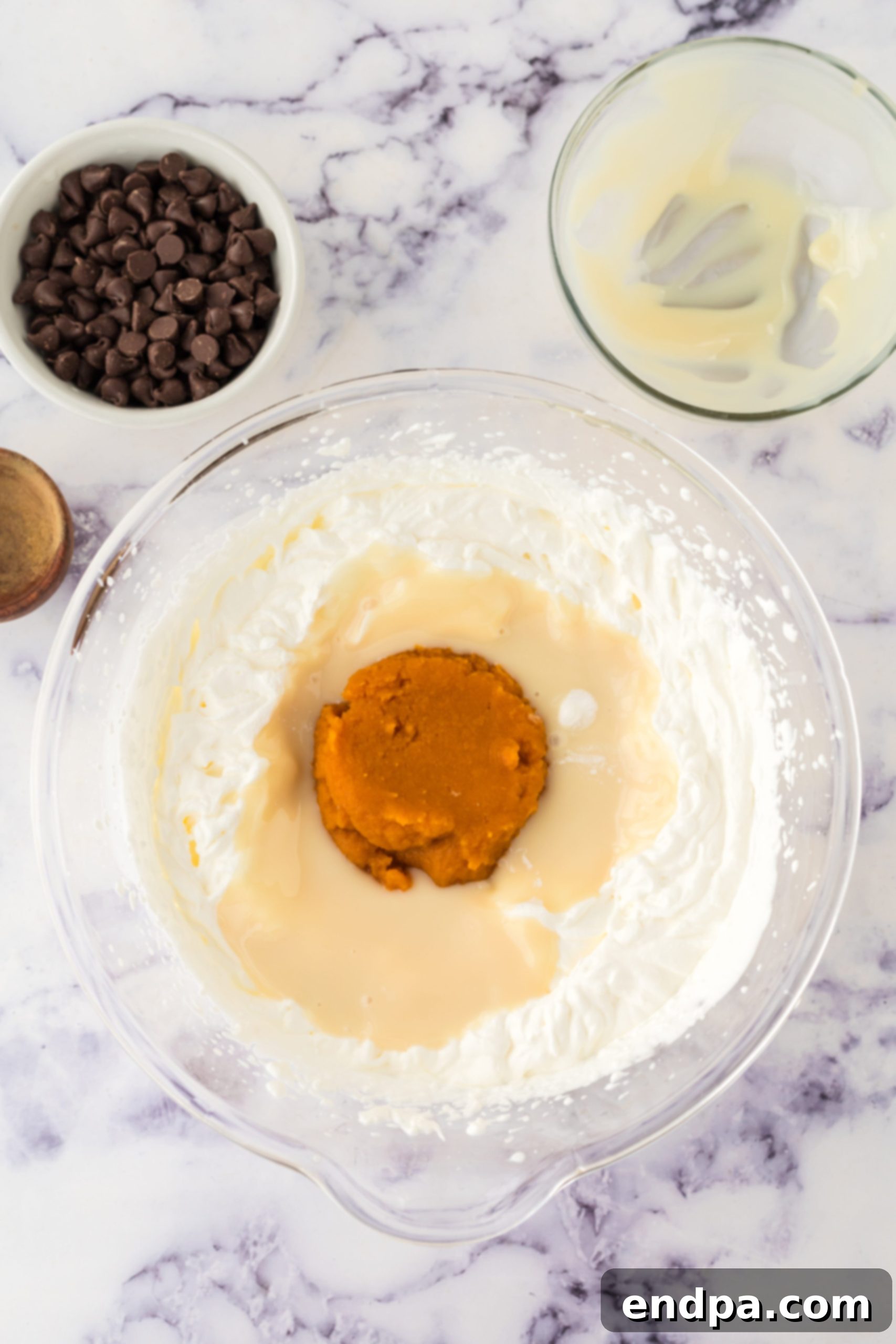 Pumpkin puree, pumpkin pie spice, and sweetened condensed milk added to whipped cream mixture.