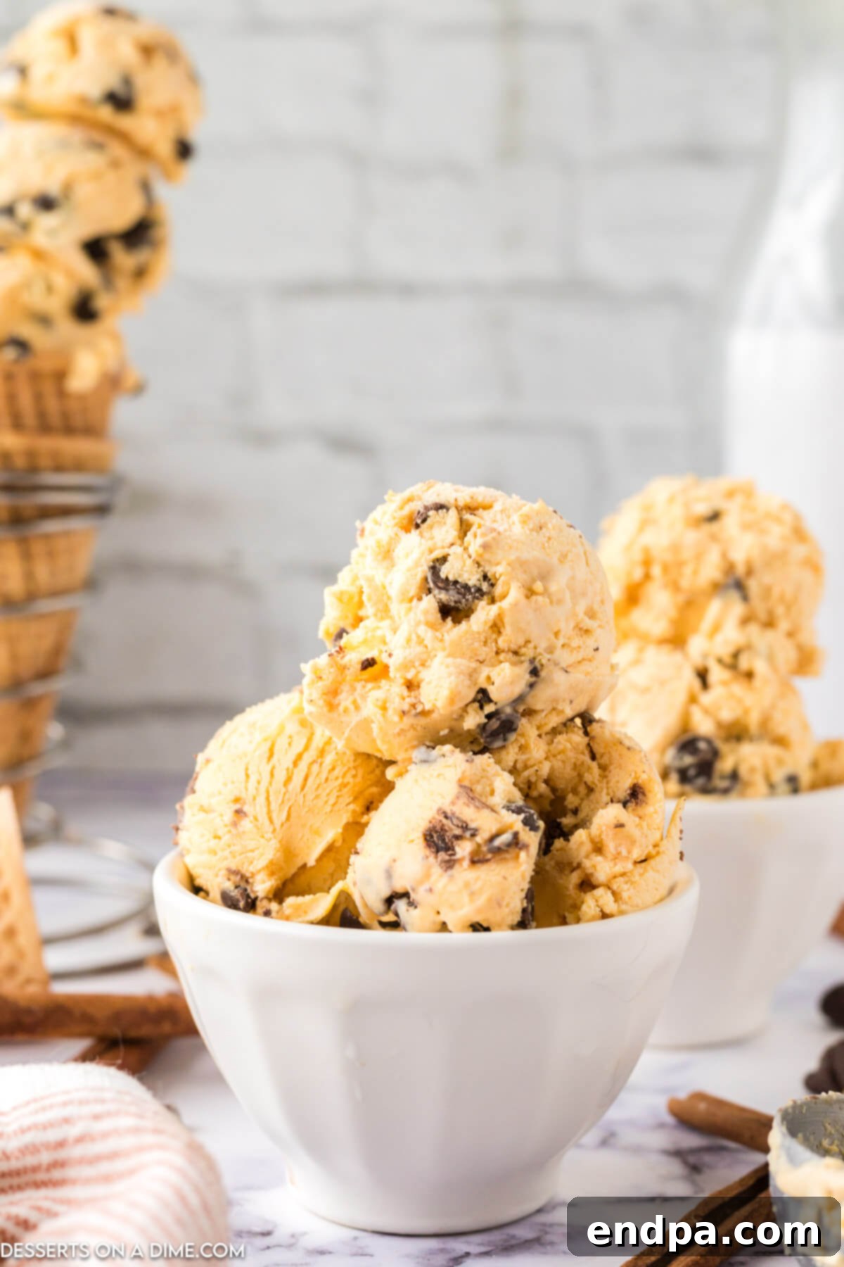 Scoops of Pumpkin Chocolate Chip Ice Cream in a white bowl, ready to be enjoyed.