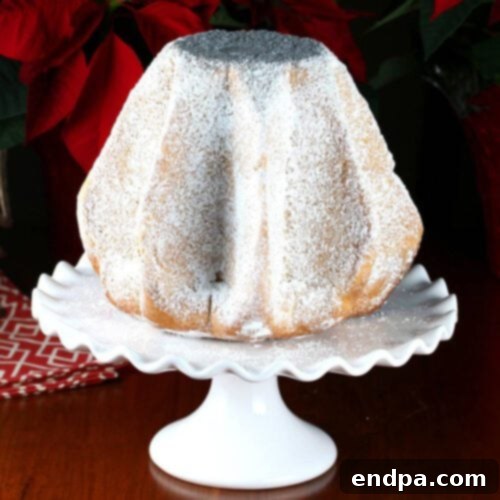A bundt cake on a cake stand with a red poinsettia.