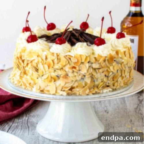 A cake with white chocolate and cherries on top.