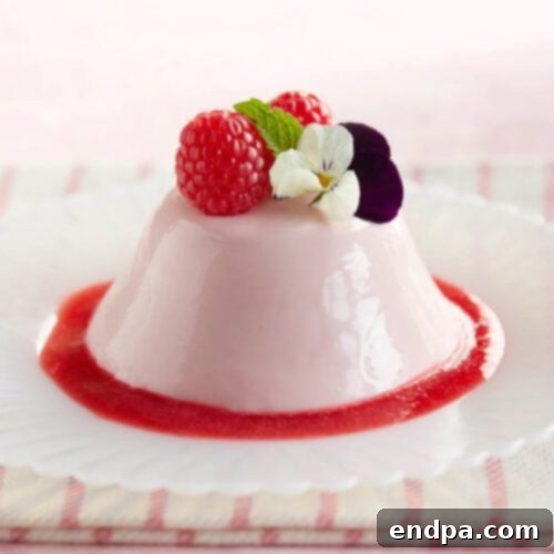 A dessert with raspberries and a flower on top.