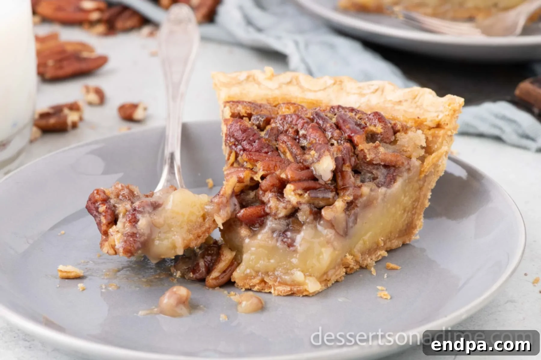 A beautiful slice of homemade Texas Pecan Pie on a white plate, showcasing its golden crust, gooey filling, and rich pecan topping. Perfect for holidays.