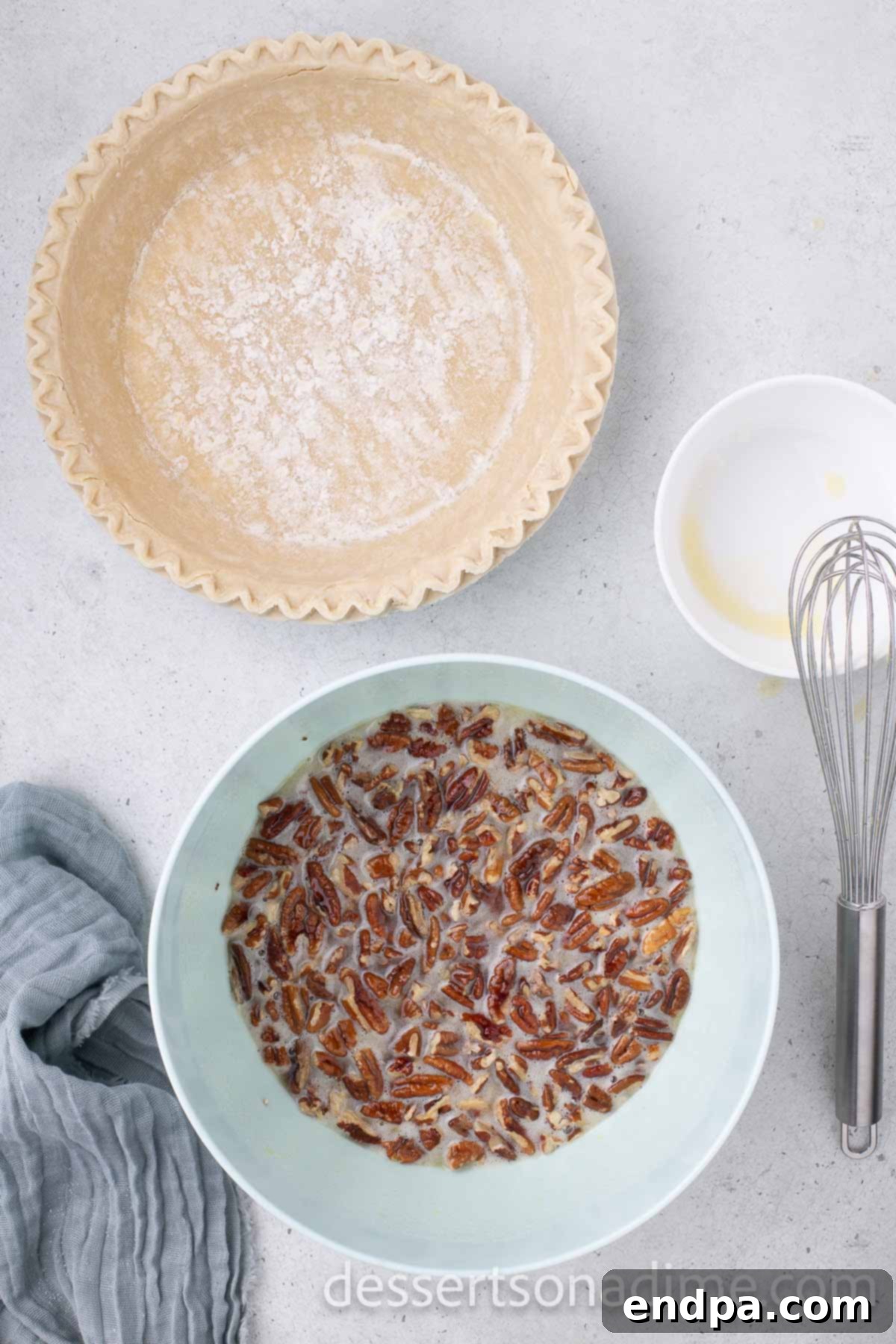 Pecan halves gently folded into the smooth pie filling mixture in a bowl.