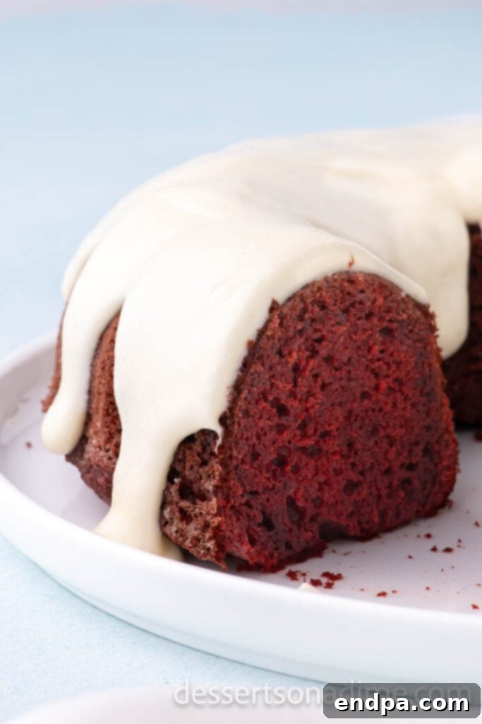 Cream Cheese Glaze drizzled on a vibrant red velvet bundt cake, showcasing its rich and creamy texture.