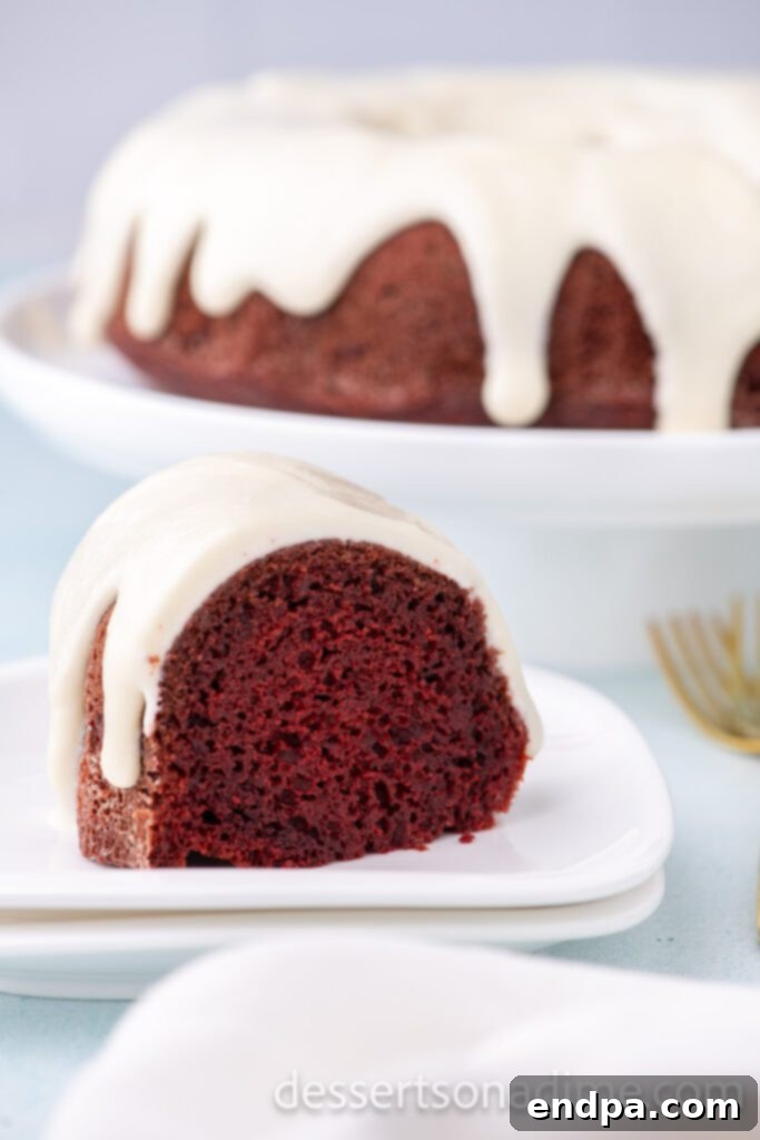 Close-up of cream cheese glaze beautifully drizzled over a red velvet bundt cake, showing its smooth texture and elegant finish.