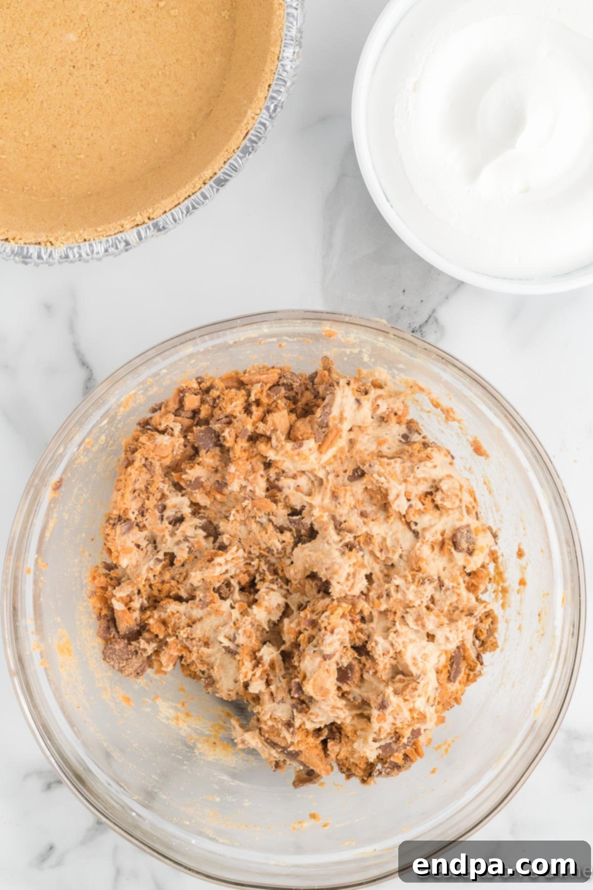 Decadent Butterfinger Crunch Pie 7 Bowl of crushed candy and peanut butter mixture being combined.