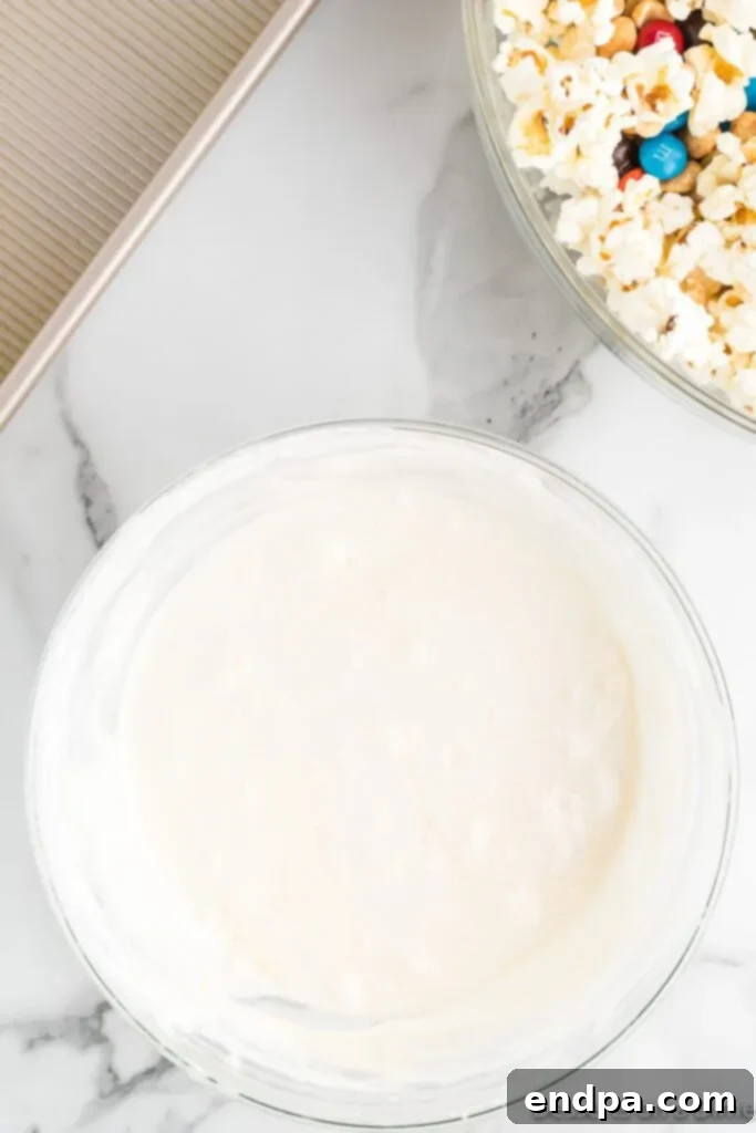 The smooth, melted marshmallow mixture, infused with vanilla and salt, glistening in a bowl, ready to be poured over the popcorn.