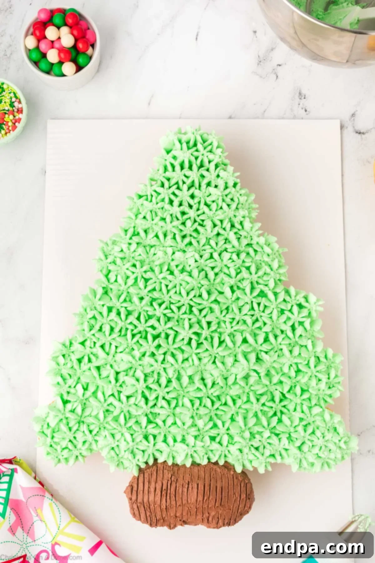 The Christmas tree cupcake cake with green frosting piped into star shapes, covering all gaps.