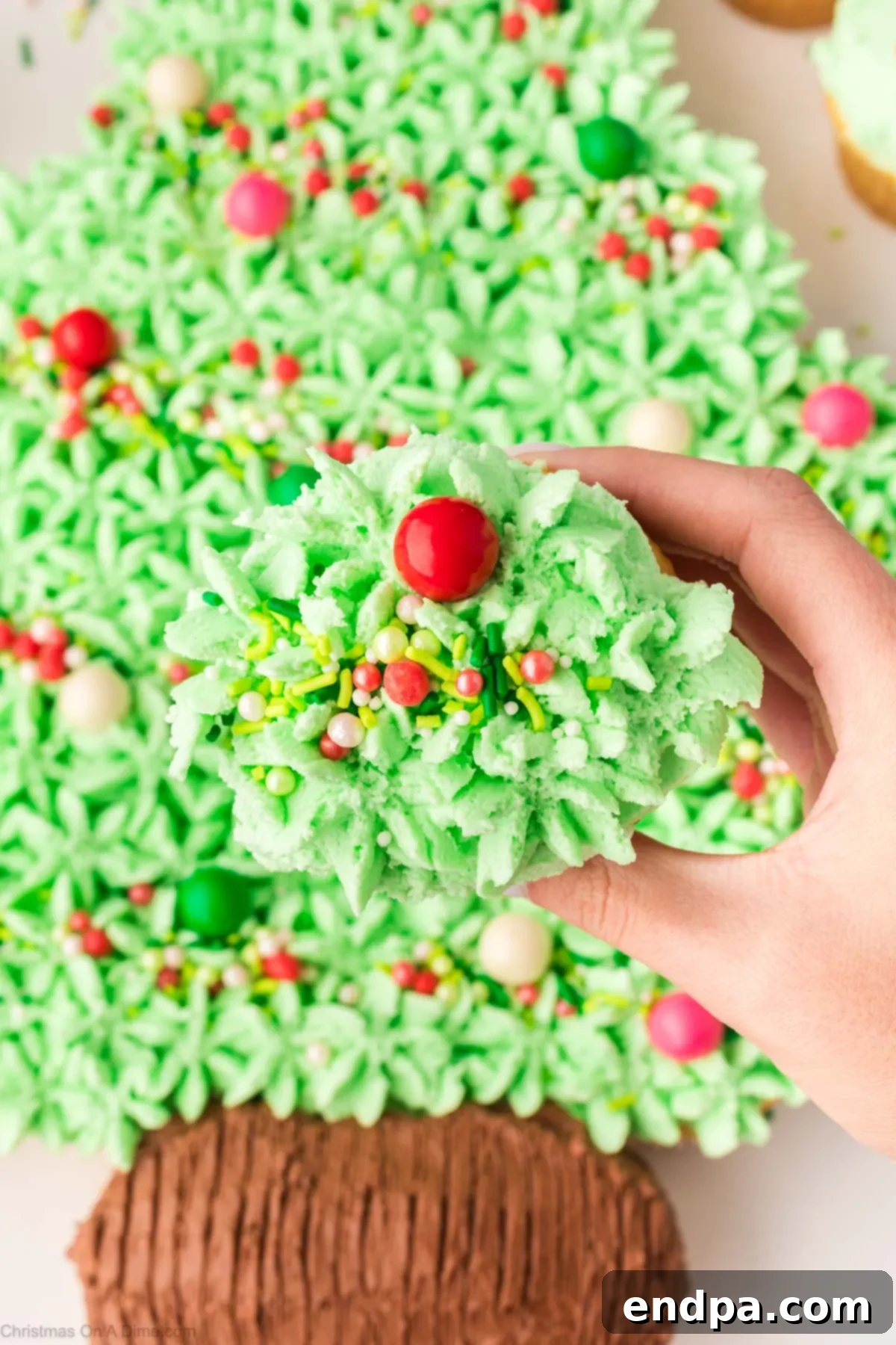 Guests pulling apart individual cupcakes from the festive Christmas tree arrangement.