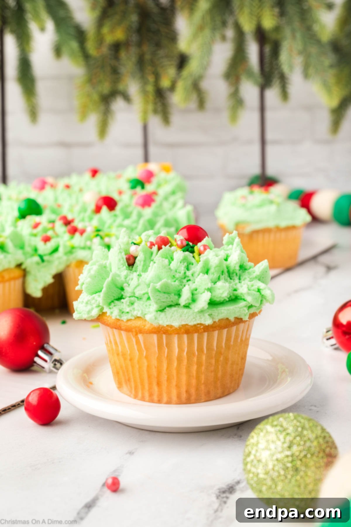 A Christmas tree cupcake cake, glistening with sprinkles, displayed beautifully on a platter.