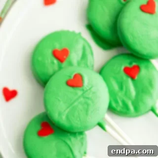 Sweet Yuletide Treasures 8 Grinch Oreo Pops, a perfect holiday dessert featuring classic Oreos dipped in melted candy and topped with a red heart.
