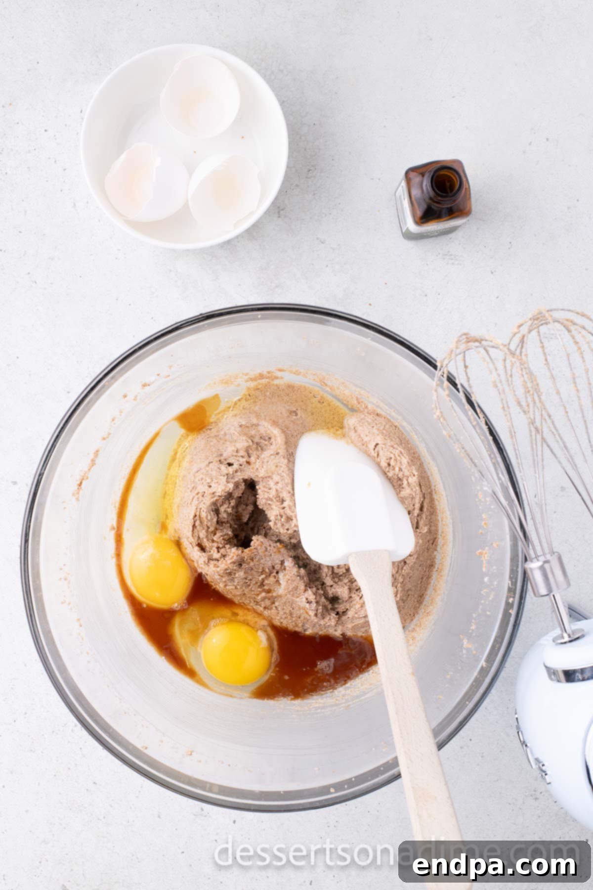 Eggs and vanilla extract added to the creamed butter and sugar mixture in a mixing bowl.