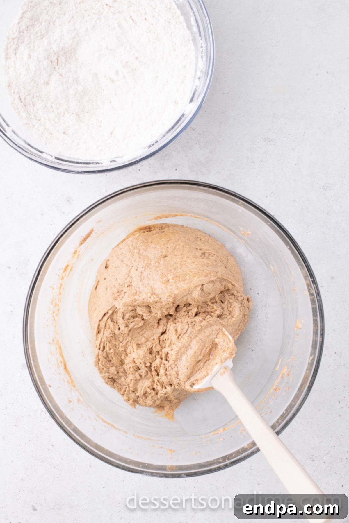 The bowl of dry ingredients about to be added to the wet mixture, with the wet mixture on the side.