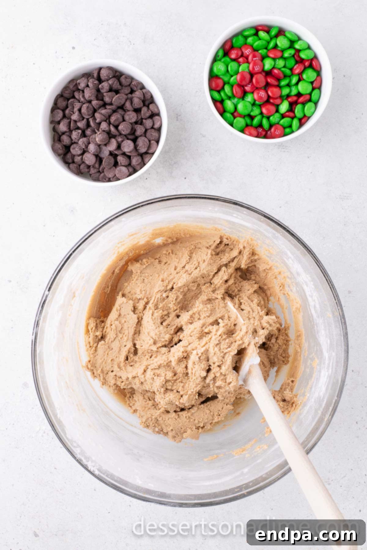 Mixing bowl with cookie dough, ready for the addition of chocolate chips and M&M candies.