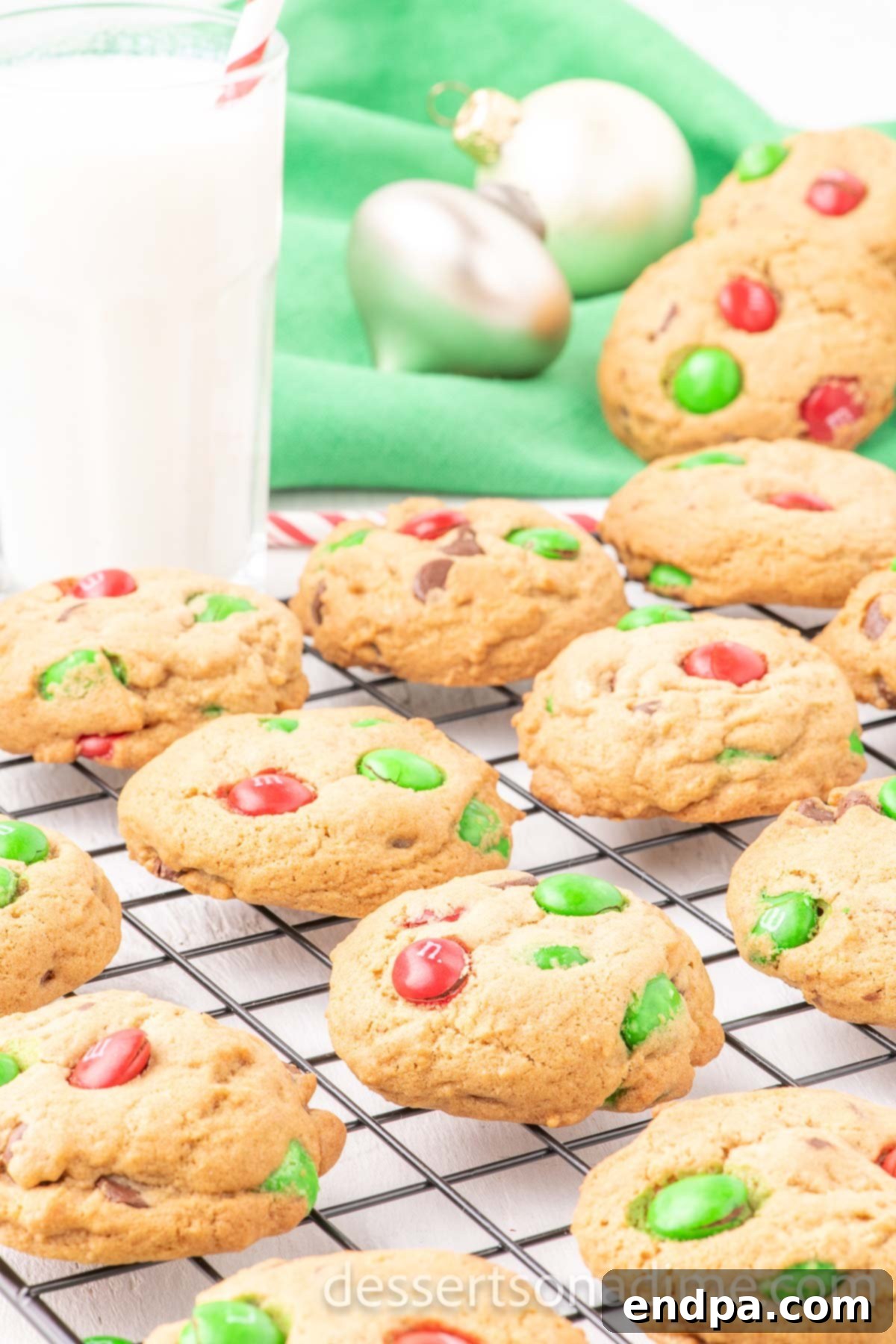 Freshly baked M&M Christmas Cookies cooling on a wire rack.