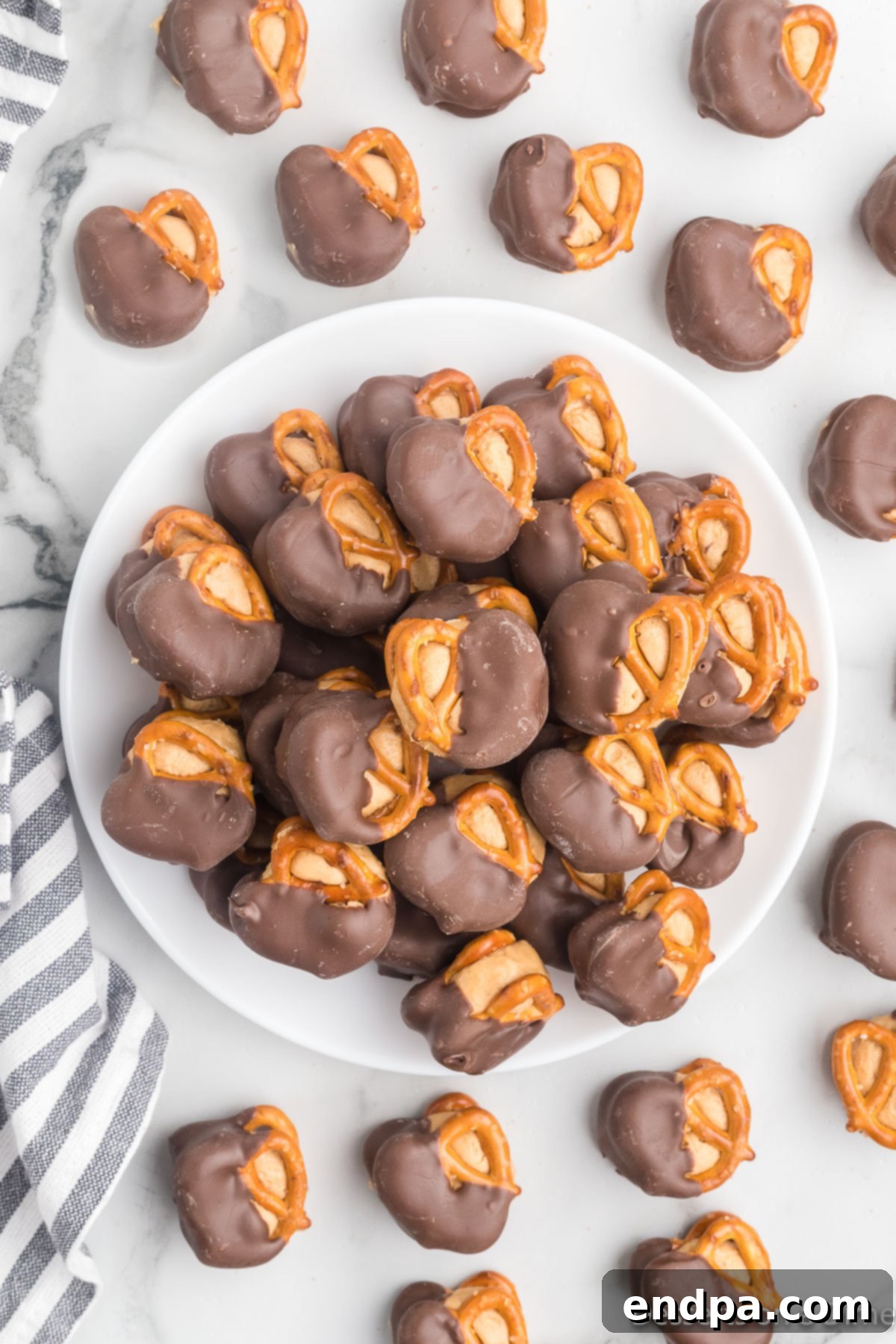Peanut Butter Pretzel Bites piled high on a pristine white plate, showcasing their perfect chocolate dip and inviting texture.
