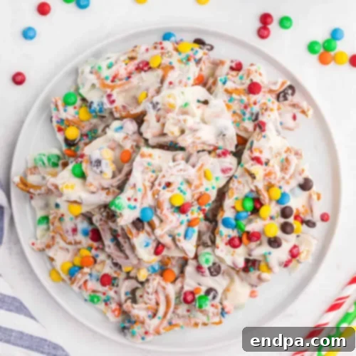 Easy, fun, and colorful no-bake White Chocolate Rainbow Bark with M&M's and pretzels.