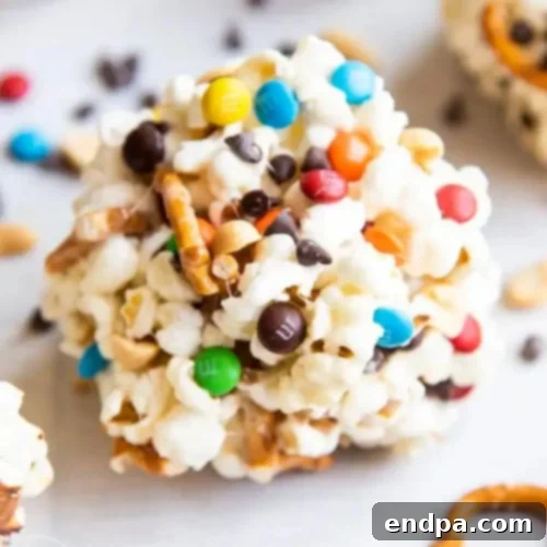 Gooey and chewy Sweet and Salty Popcorn Balls packed with pretzels, peanuts, M&M's, and chocolate chips.