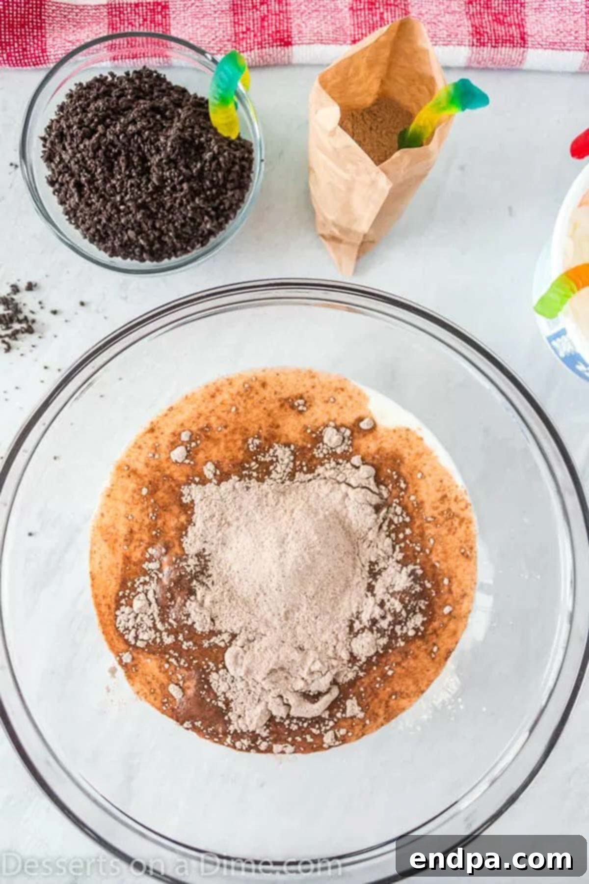 Delicious Dirt Cup Delight 3 Combining instant chocolate pudding mix with cold milk in a large mixing bowl.