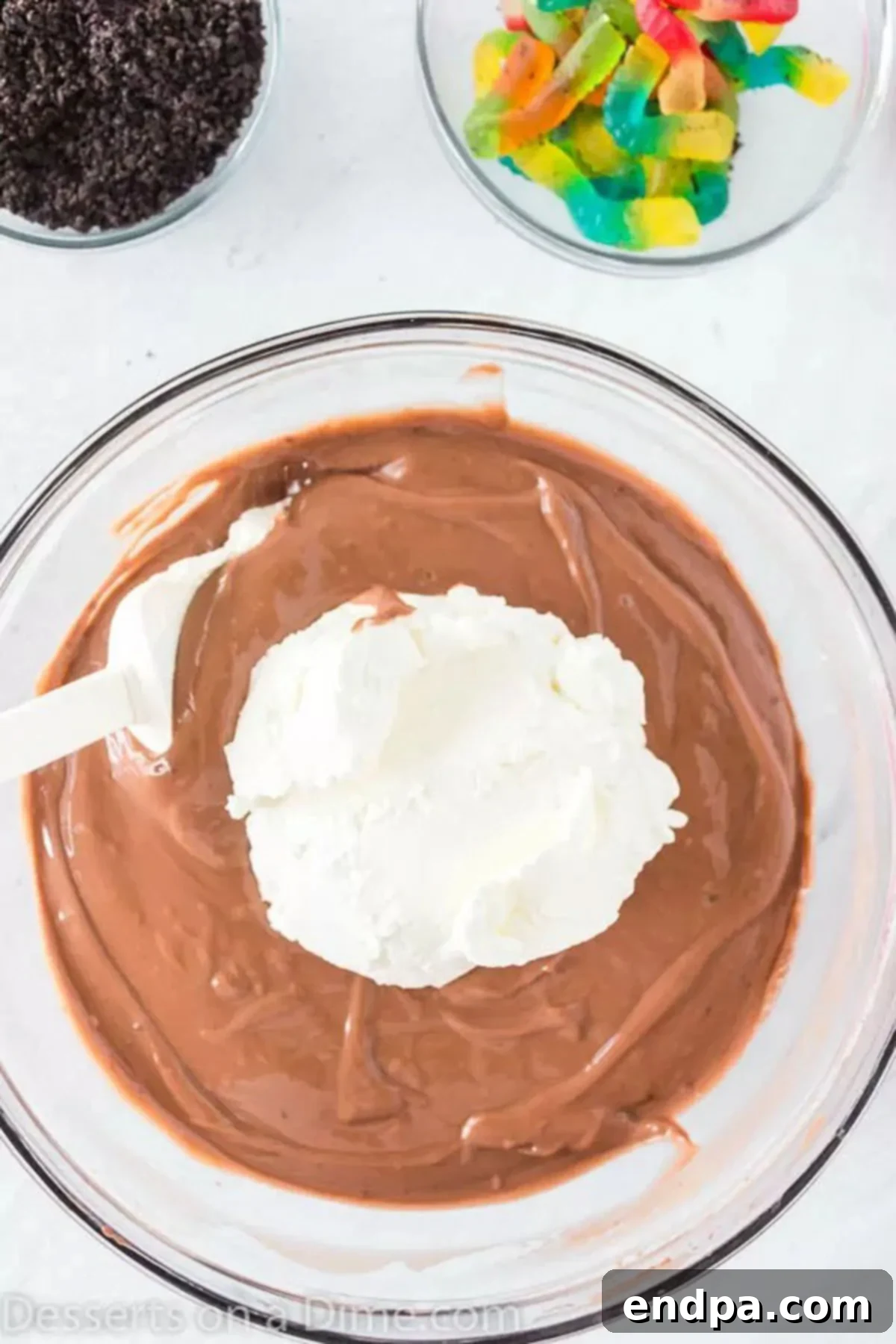 Delicious Dirt Cup Delight 4 Gently folding the thawed whipped topping into the set chocolate pudding mixture.