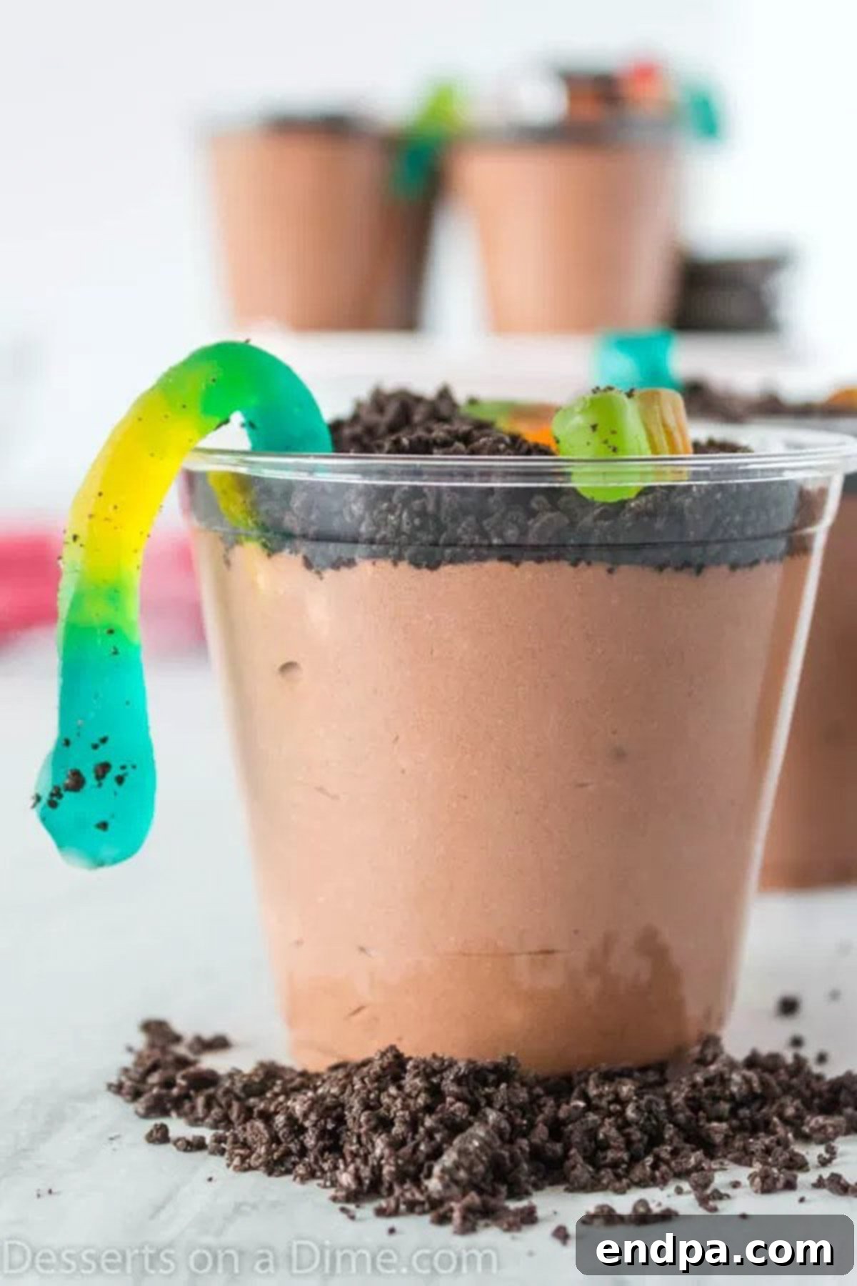 Delicious Dirt Cup Delight 7 Completed Dirt Cups arranged beautifully, with gummy worms emerging from the crushed Oreo topping, ready to serve.