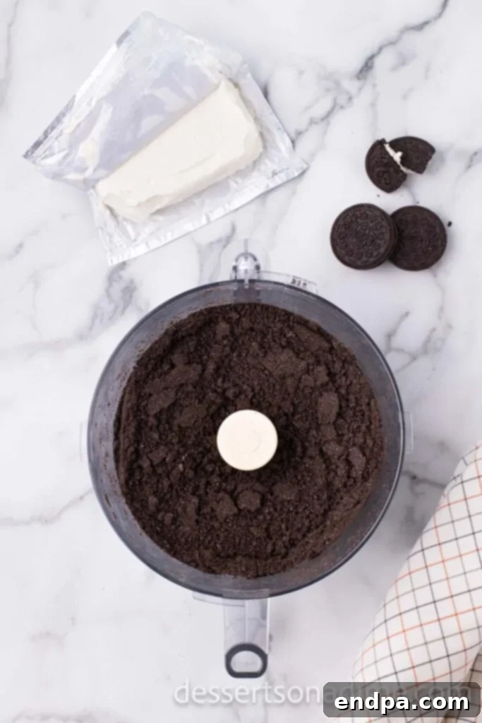 Oreo cookies being finely crushed in a food processor.