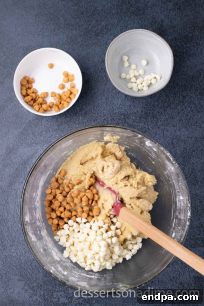 Hogsmeade's Secret Butterbeer Cookie Recipe 7 Folding butterscotch chips and white chocolate chips into the prepared cookie dough batter in a mixing bowl.