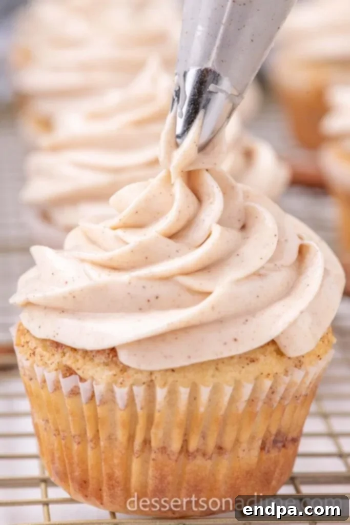 Heavenly Snickerdoodle Cupcakes 11 Piping the frosting on the cupcake