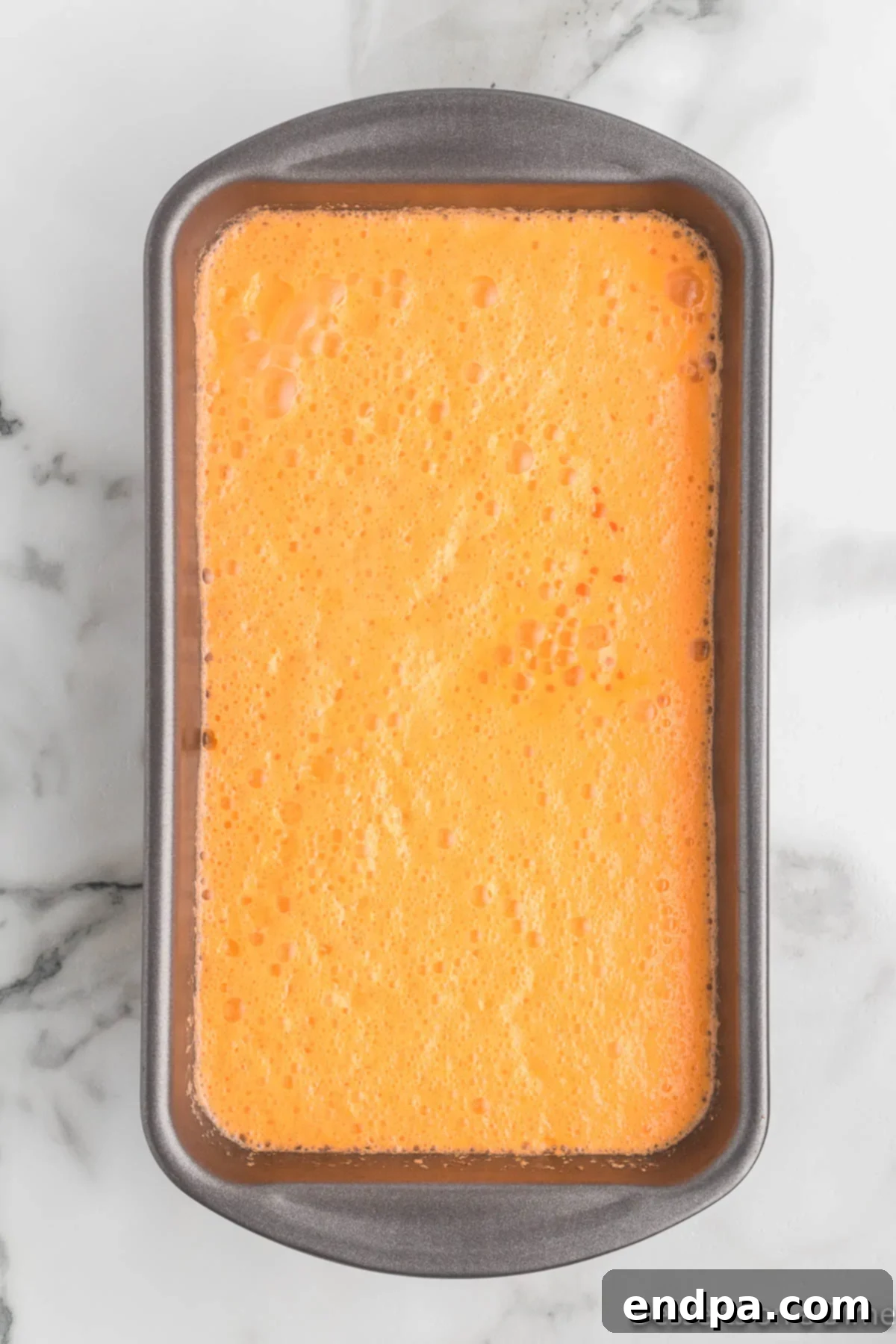 Sunset Swirl 6 Orange sherbet mixture poured evenly into two loaf pans, ready for freezing.