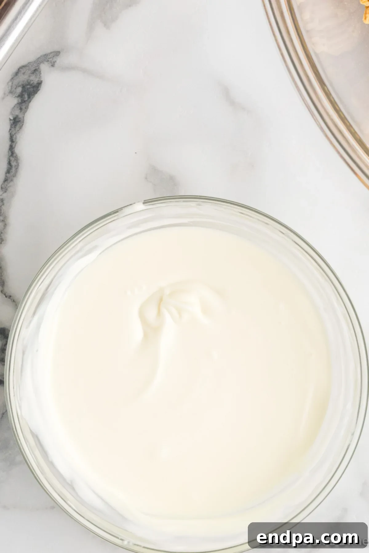 Melted white chocolate in a microwave-safe bowl, smooth and ready for use.