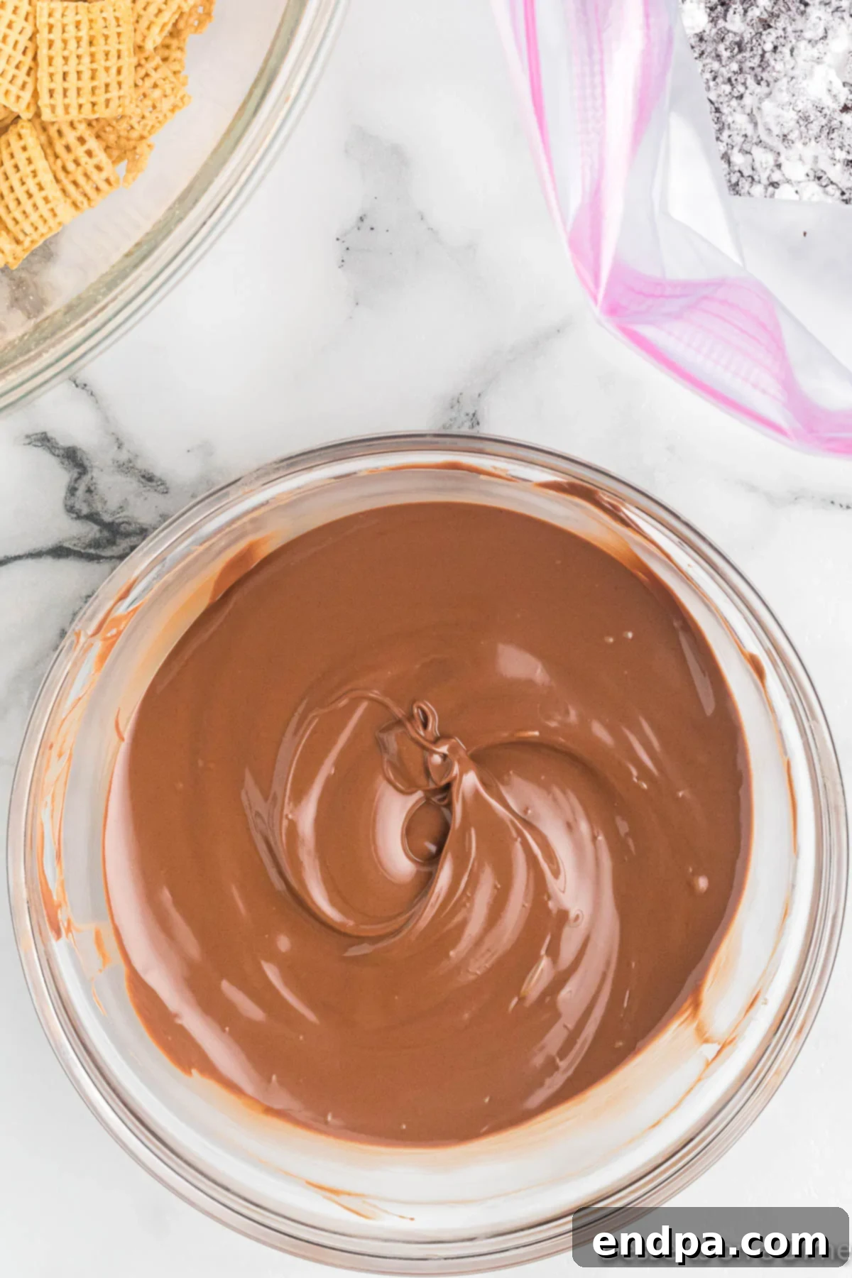 Melted milk chocolate in a bowl, smooth and ready to coat cereal.
