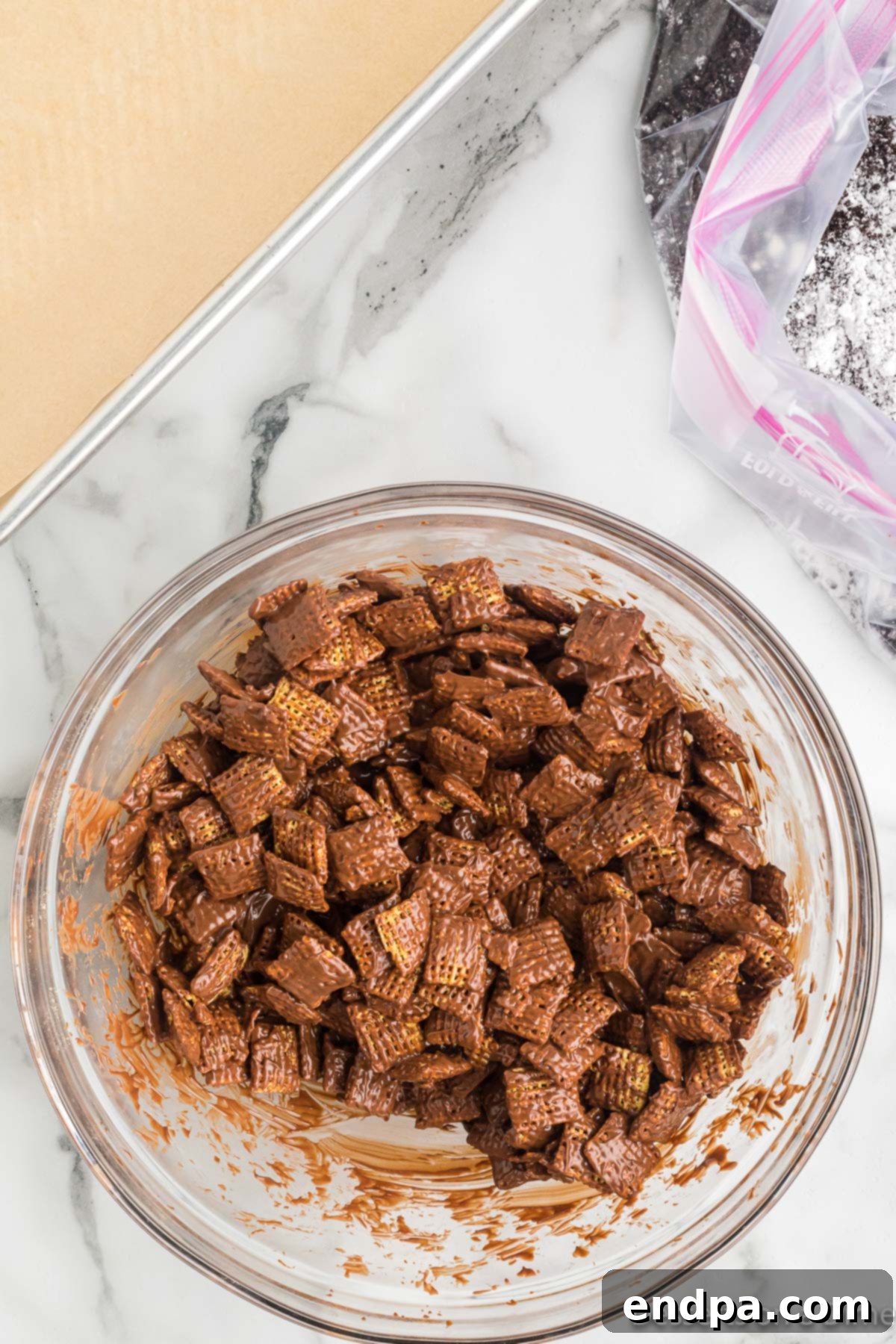 Chex cereal coated evenly in the melted milk chocolate mixture.