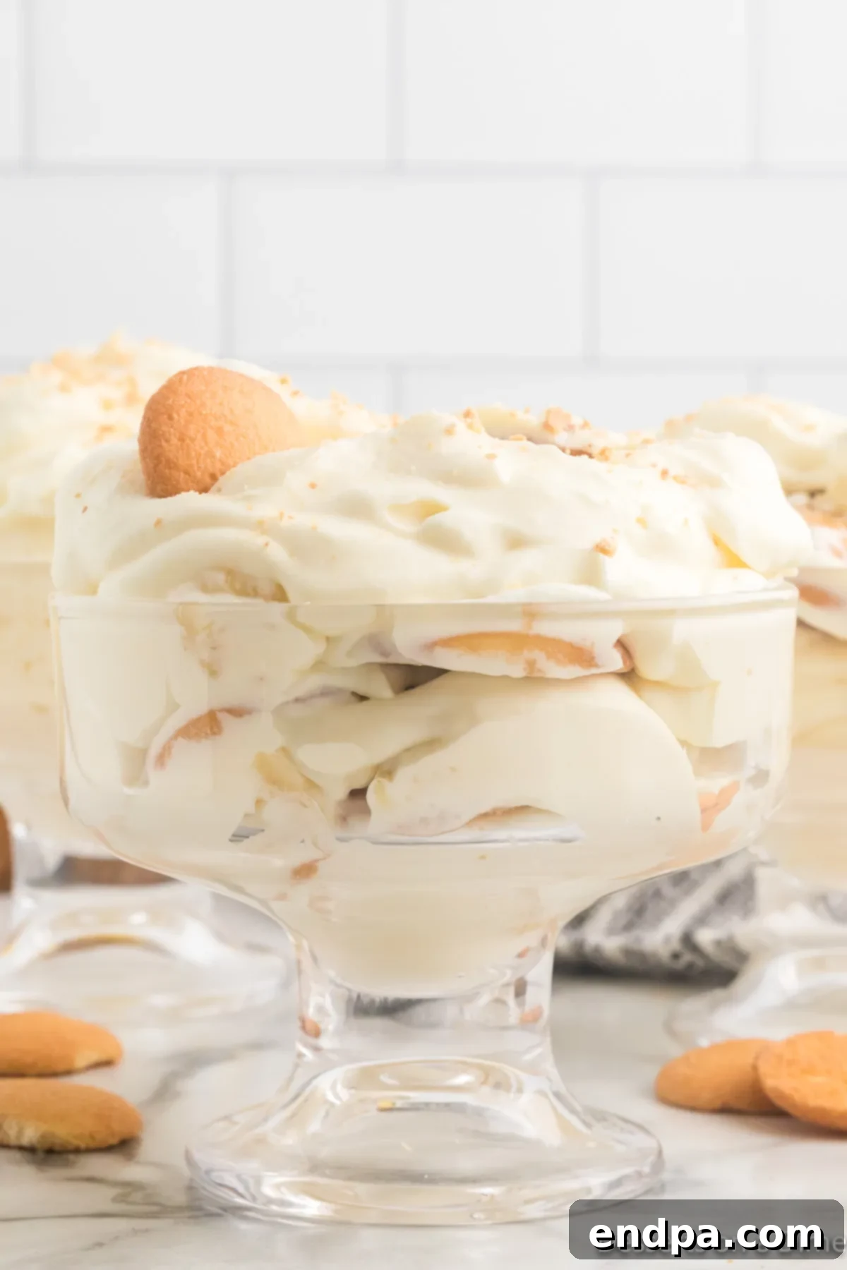 Homemade Magnolia Bakery Banana Pudding Perfection 2 Glass dish with Magnolia banana pudding, showcasing its decadent layers of vanilla pudding, whipped cream, and bananas.