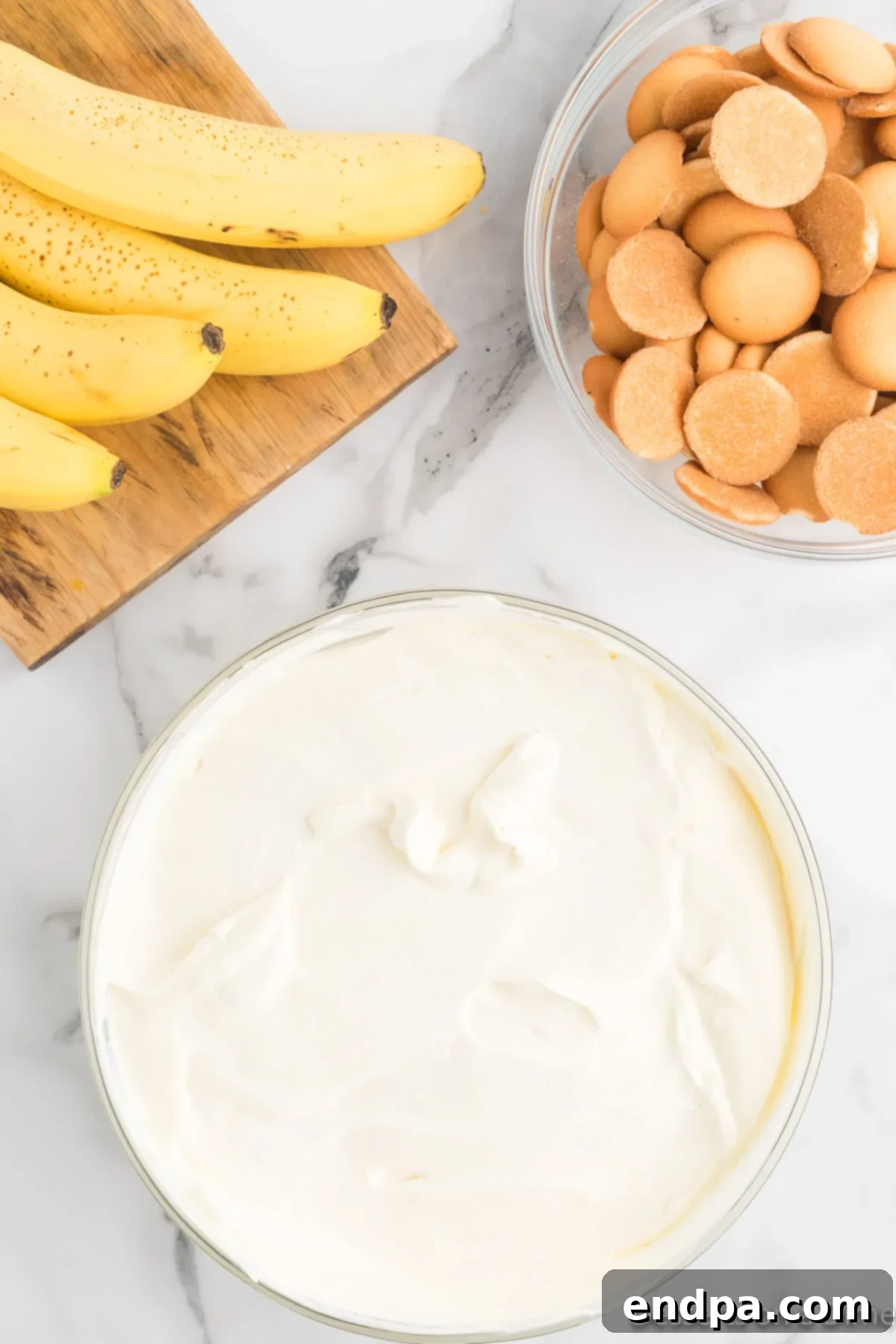 Homemade Magnolia Bakery Banana Pudding Perfection 9 Pudding layered in a glass dish, with whipped cream on top and ready to chill.