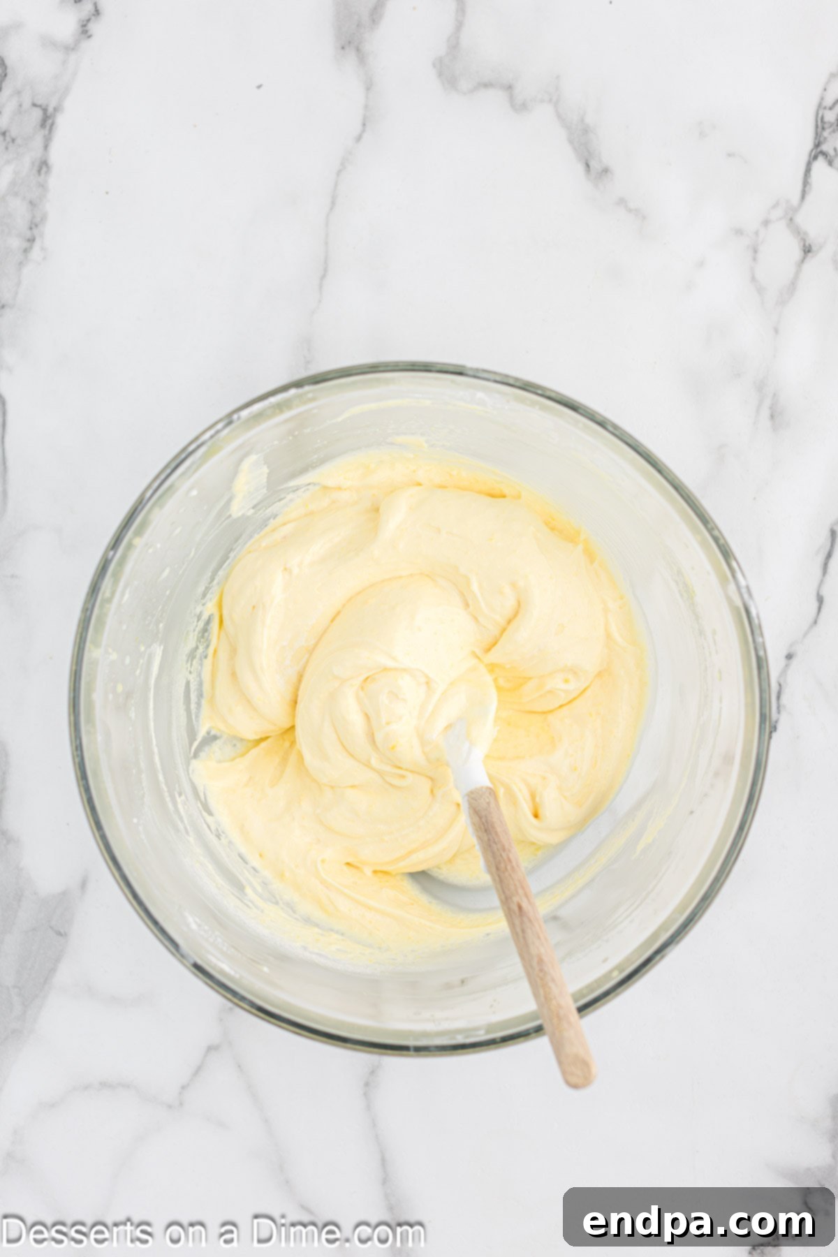 Gourmet Eclair Cupcakes 5 A bowl of freshly whipped cream being gently folded into the thickened pudding mixture, creating a light and airy Eclair Cupcake filling.