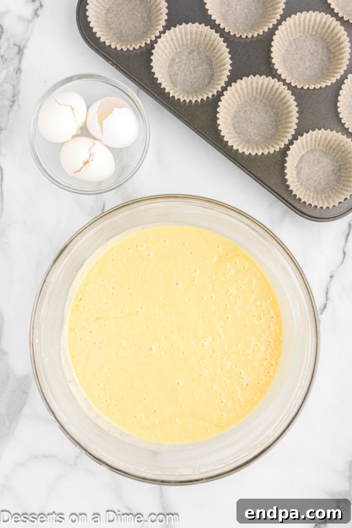 Gourmet Eclair Cupcakes 6 A bowl of smooth, pale yellow cupcake batter, perfectly mixed and ready to be poured into liners for baking.