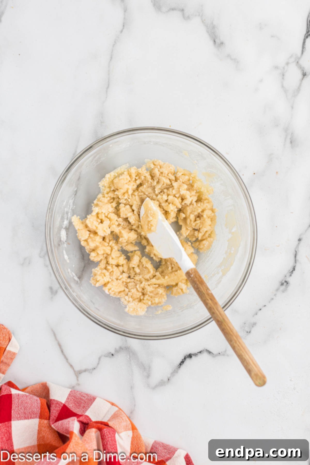 Combining the biscuit topping in a bowl with a spatula