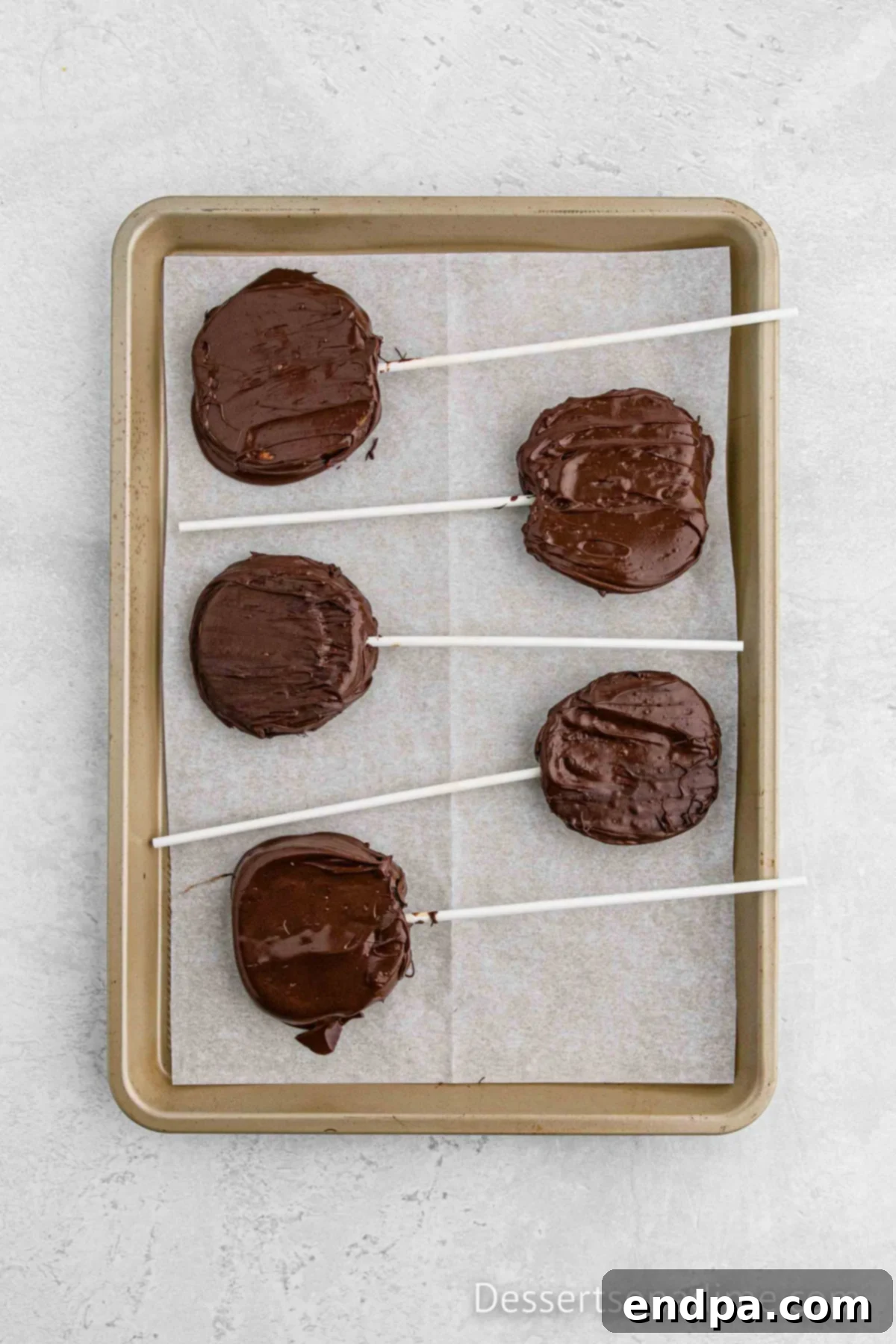 Coated Chocolate Apple Slices drying on a pan with wax paper.