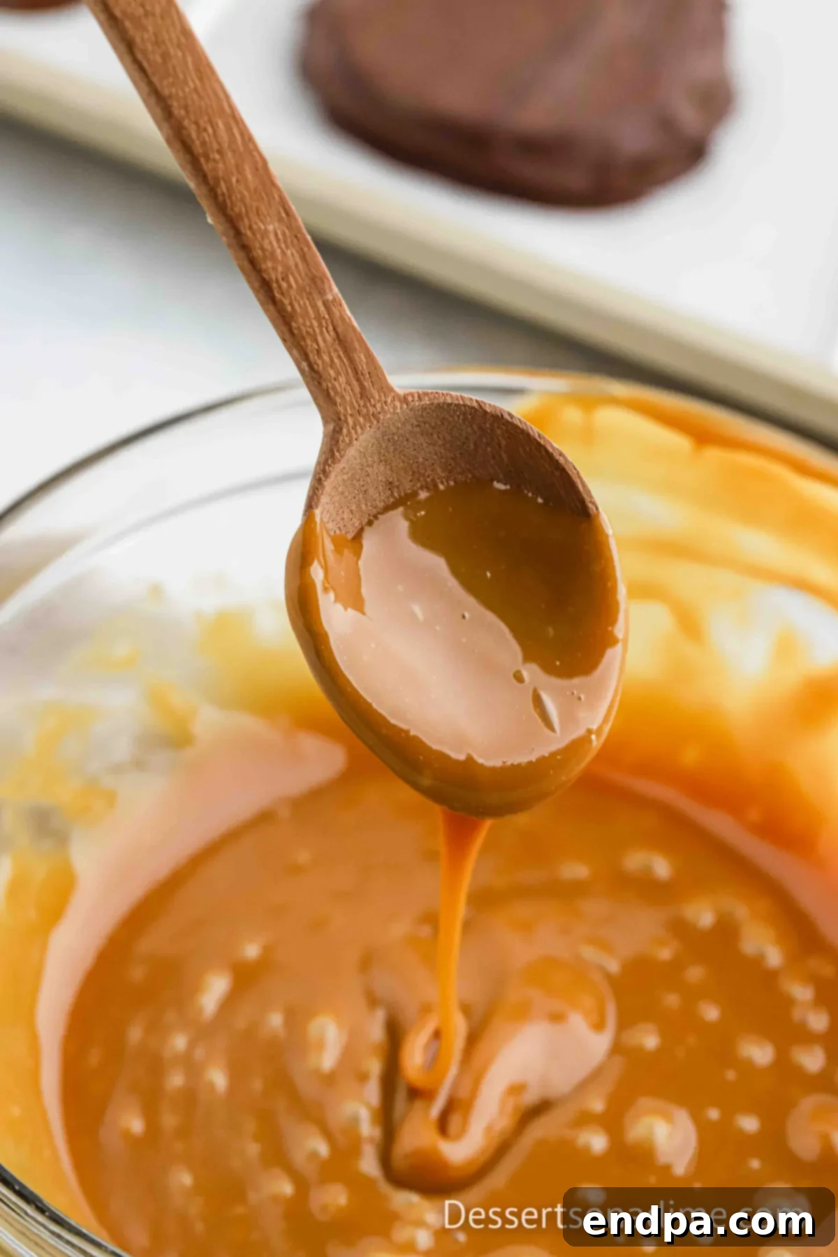 Caramel in a bowl melted with a wooden spoon.