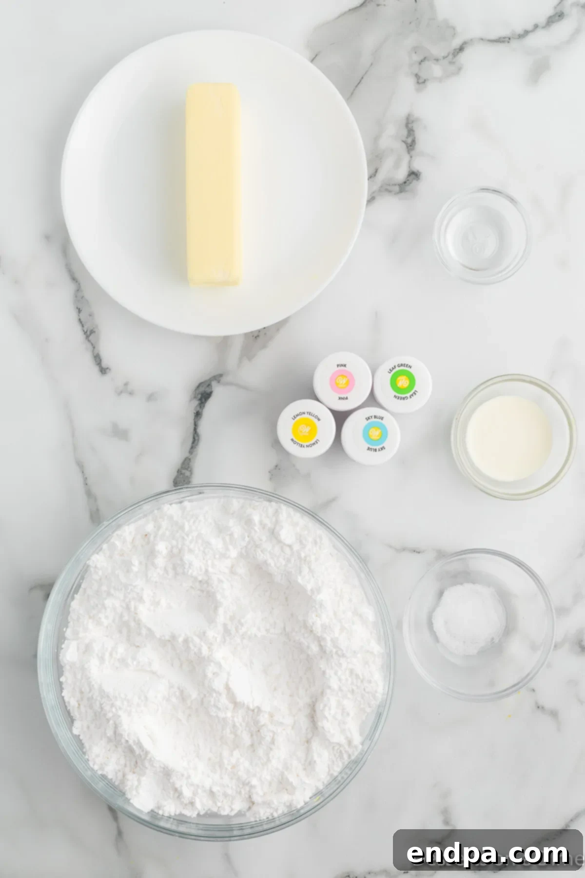 Creamy Mint Delights 3 Ingredients for butter mints laid out: softened unsalted butter, powdered sugar, various food coloring bottles, heavy cream, and a small dish of salt.